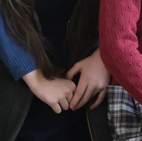Closeup of a child's hands wrapped around a person's torso the person is wearing a jacket with a zipper that suddenly...