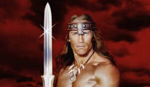 Arnold Schwarzenegger wields a huge sword on the poster for Conan the Barbarian.