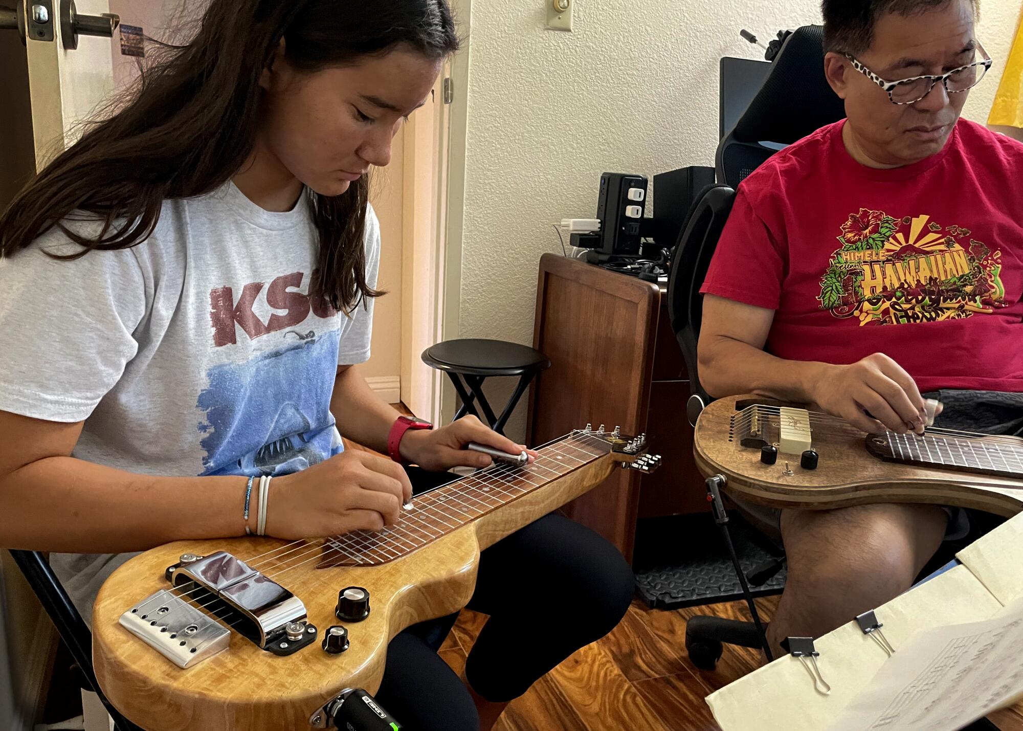 A student learns Hawaiian steel guitar.