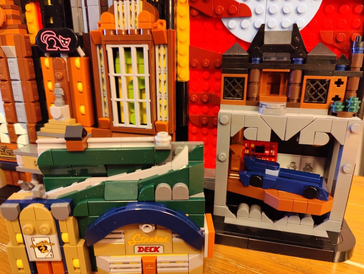 A detail of Lego's Gotham City set showing the hidden Batmobile hiding behind a reoved building piece