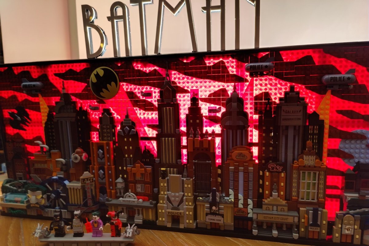 The completed LEGO Gotham City Batan set standing on a table in the dark backlit to make it glow red
