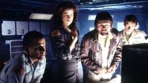 Four members of the Nostromo look at a screen in Alien, and Alien is returning to theaters