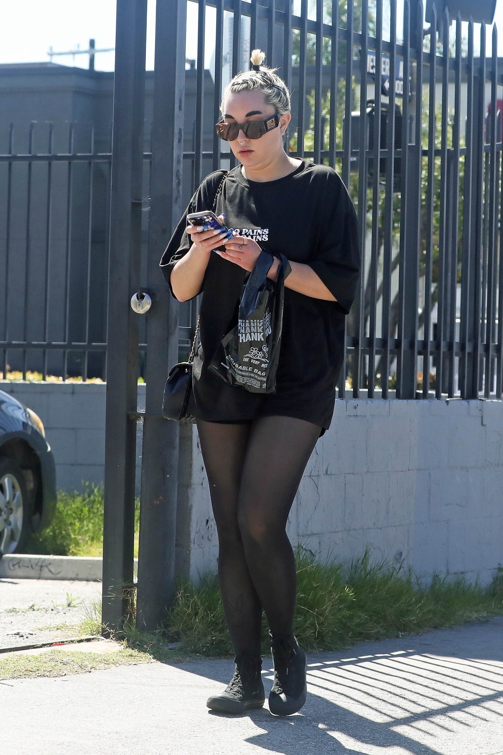 She wore sheer black leggings, a baggy graphic T-shirt, boots, and her hair in a tight bun