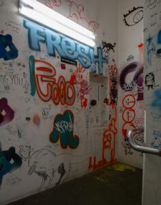 white walls in a stairwell covered in graffiti and drawings