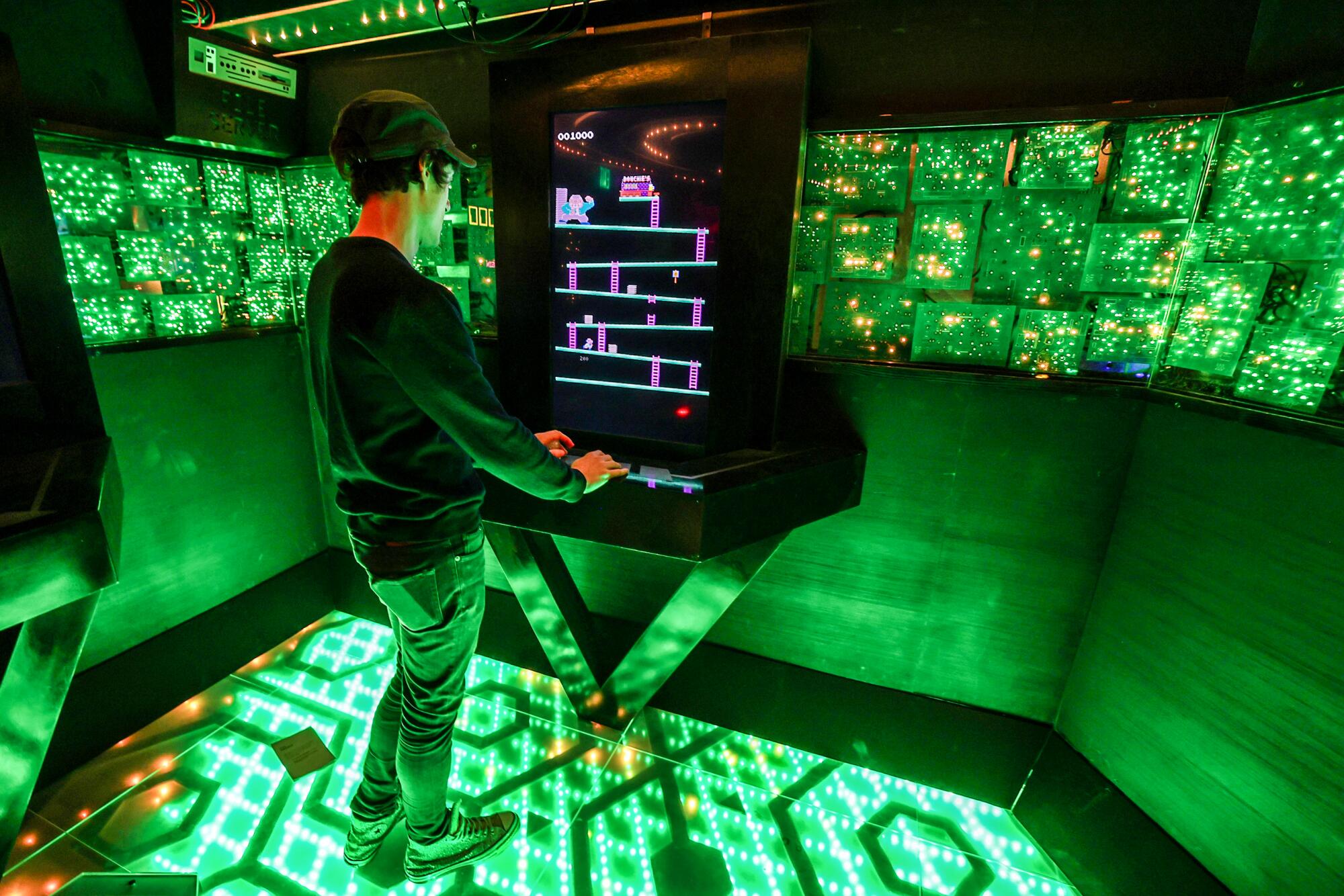 A young man plays "Bossy Kong," an '80s-themed video game
