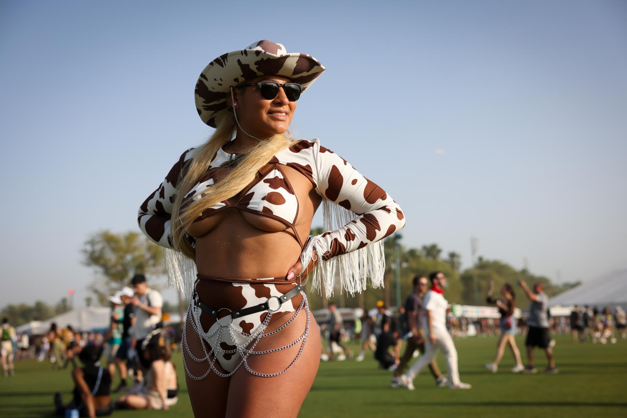 Brenda Ramirez, 33, of Chula Vista, glistens in the desert sun wearing a cow print ensemble at Coachella.