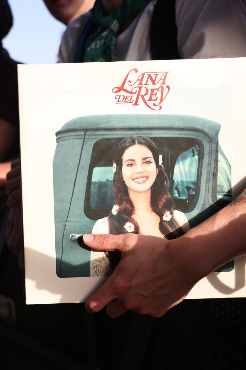 A fan holds a Lana Del Rey album in the front row at Coachella.