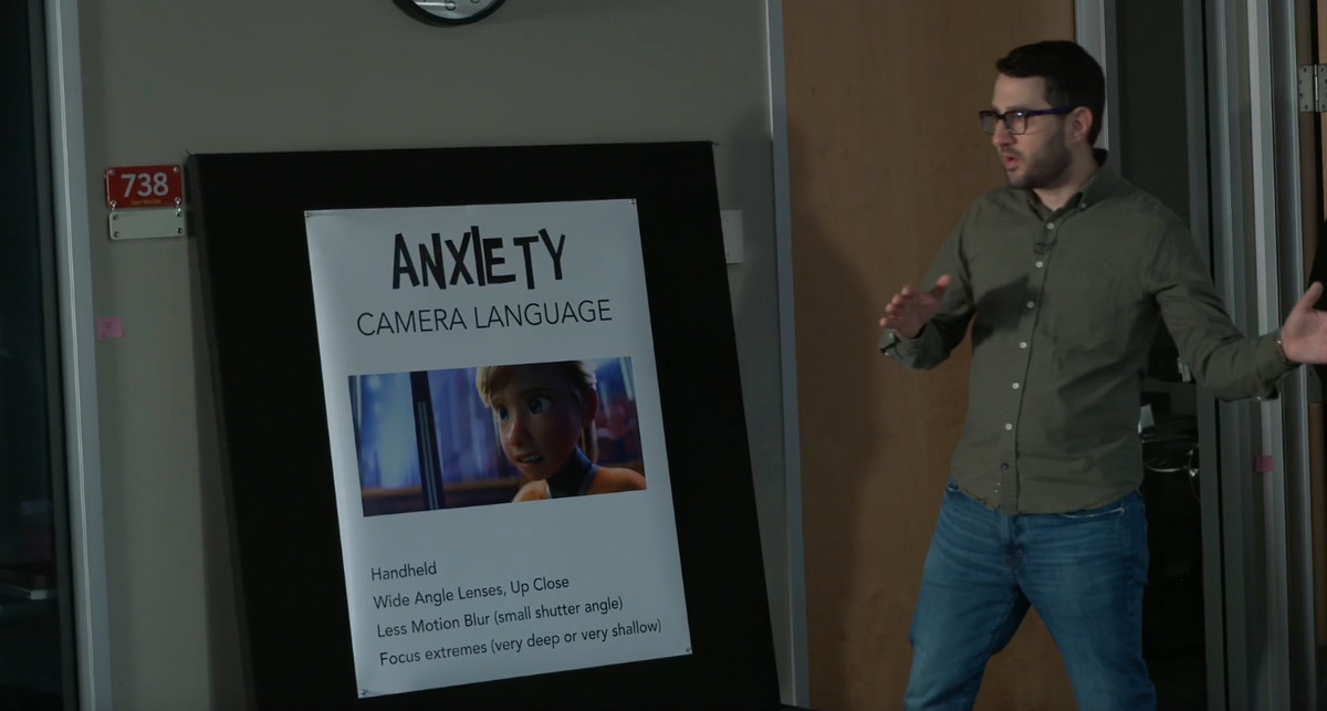 Director of layout photography Adam Habib points at a sign detailing the anxiety camera language.