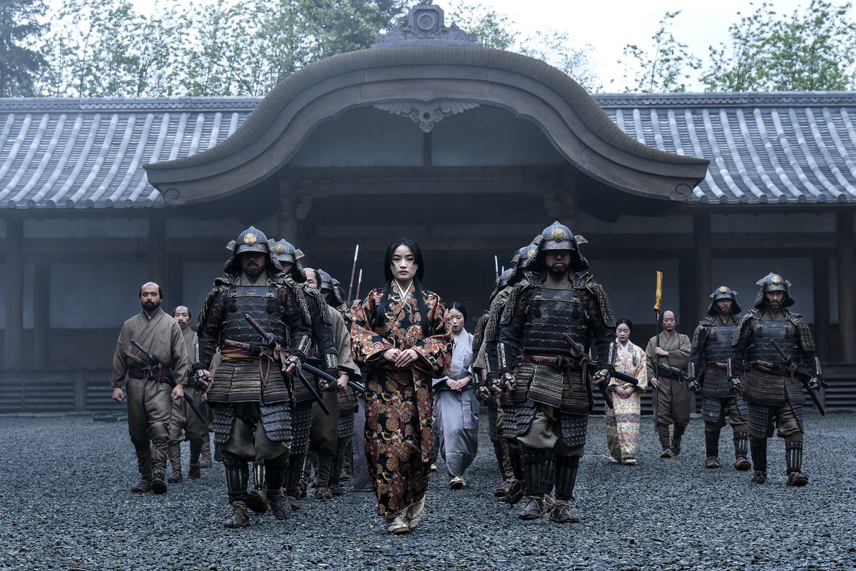 Anna Sawai is flanked by samurai as she walks towards the camera in Shogun
