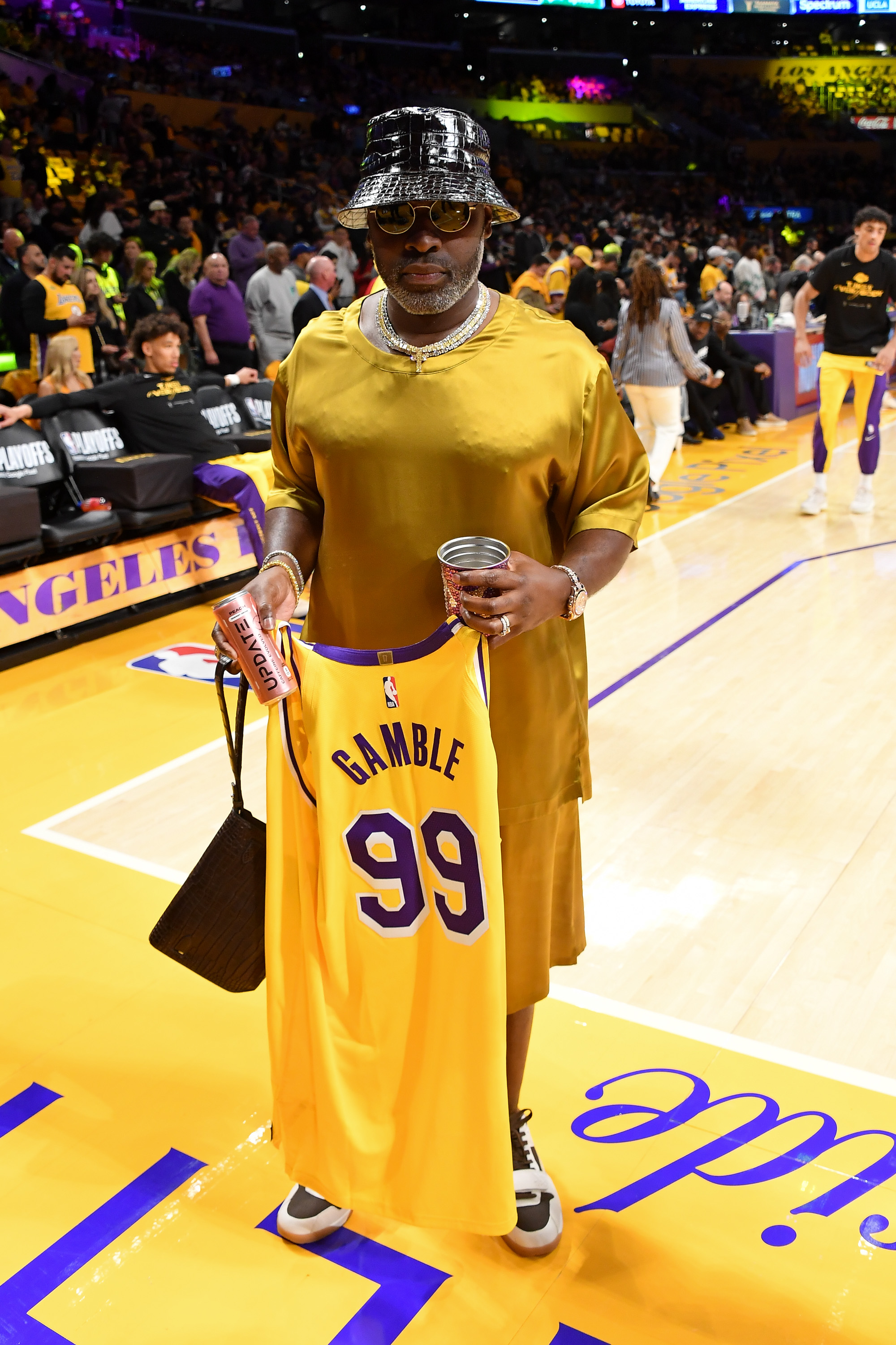 Corey held out his Lakers jersey while standing at the basketball court