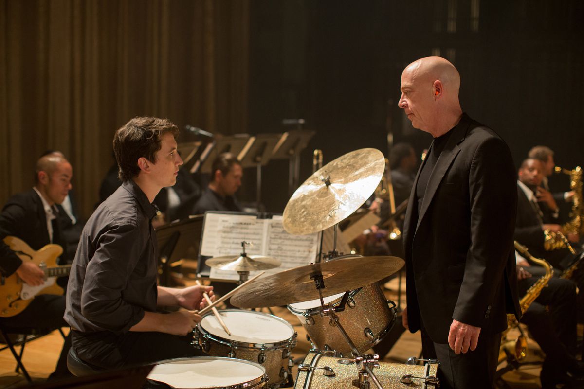 Andrew Neiman (Miles Teller) sits at a drumstand across from his bandleader Fletcher (JK Simmons) in Whiplash.