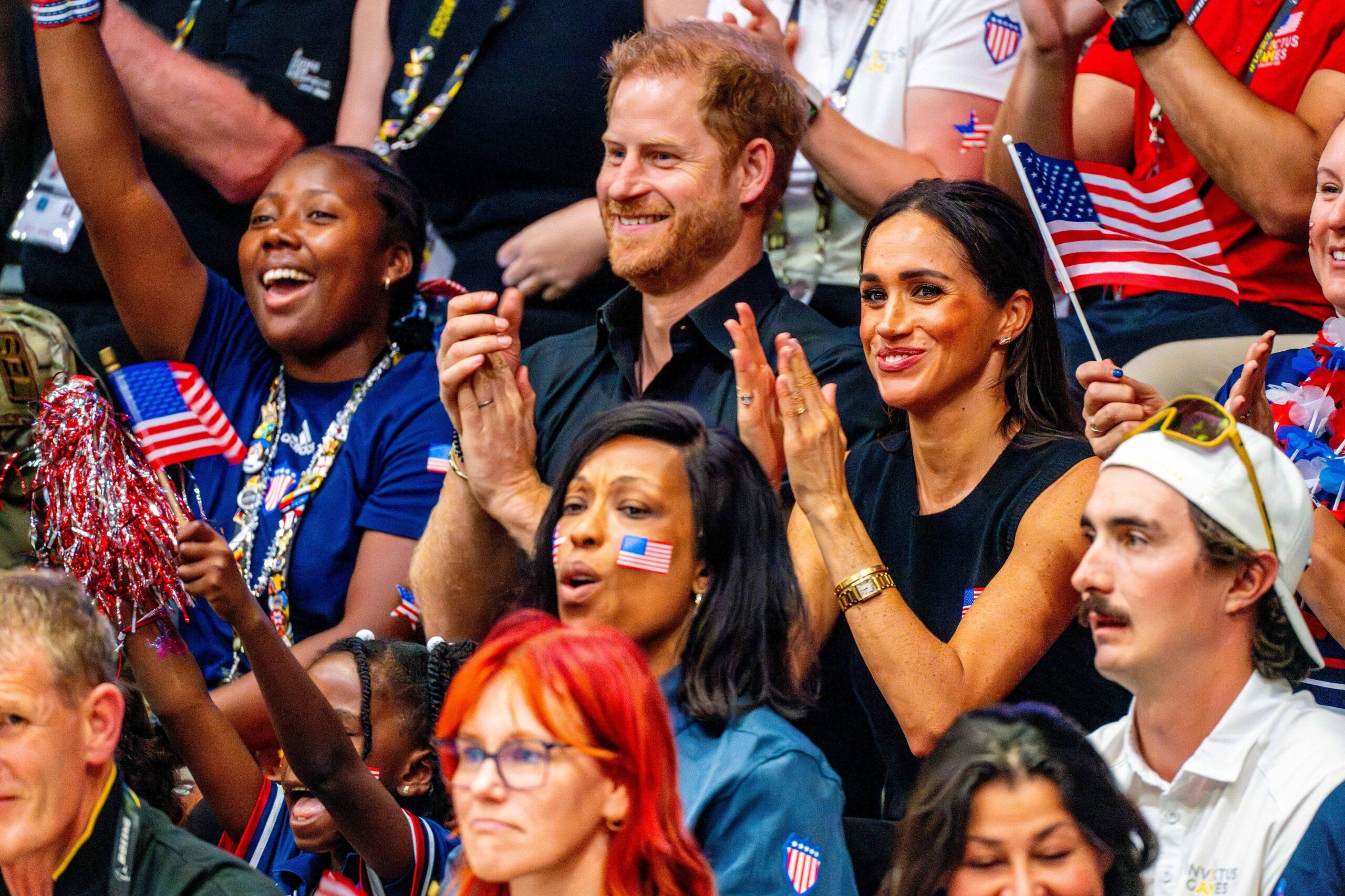 Prince Harry & Meghan Markle smiling and clapping