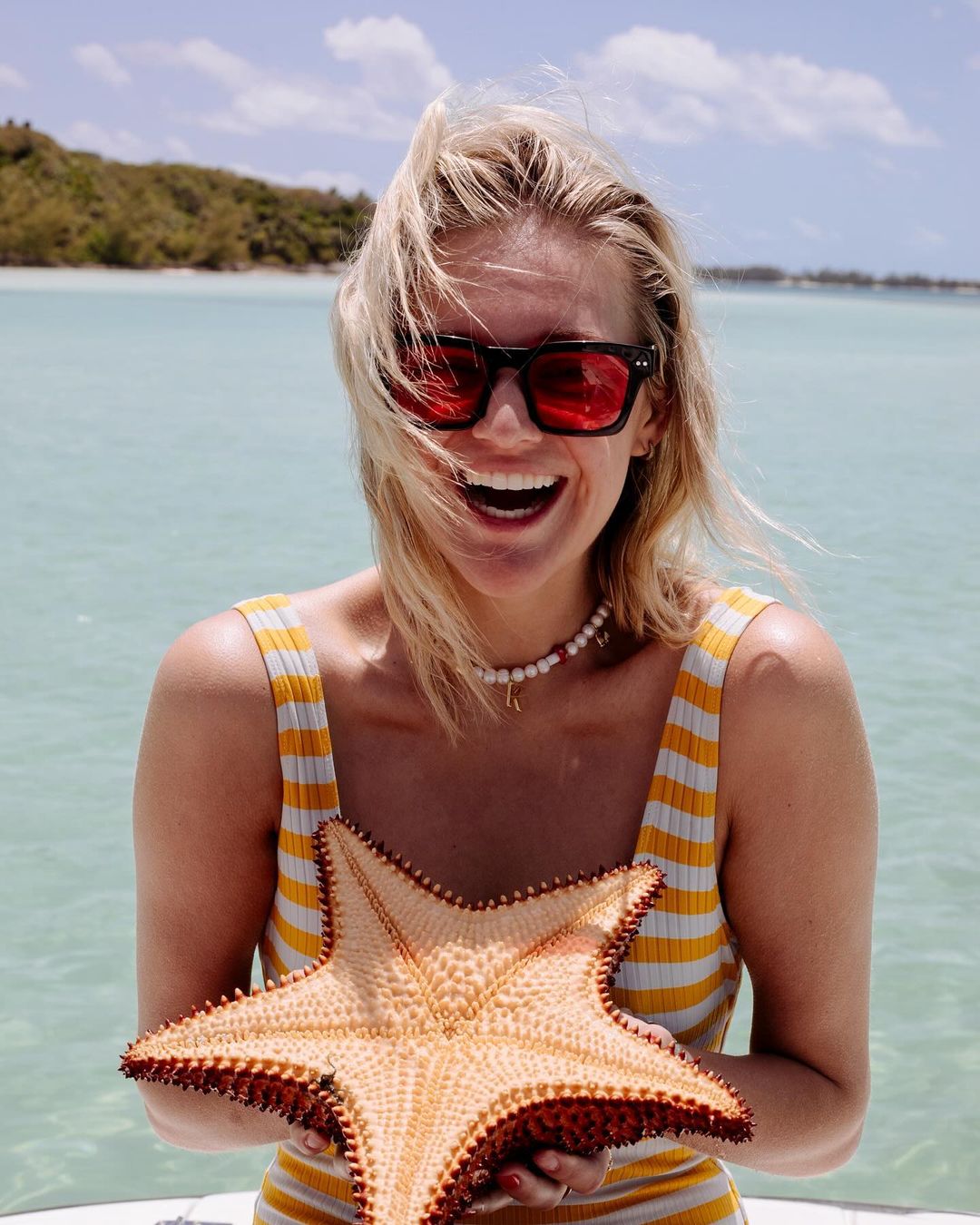 The first pic showed the I Quit Drinking singer laughing on a boat while holding a giant starfish