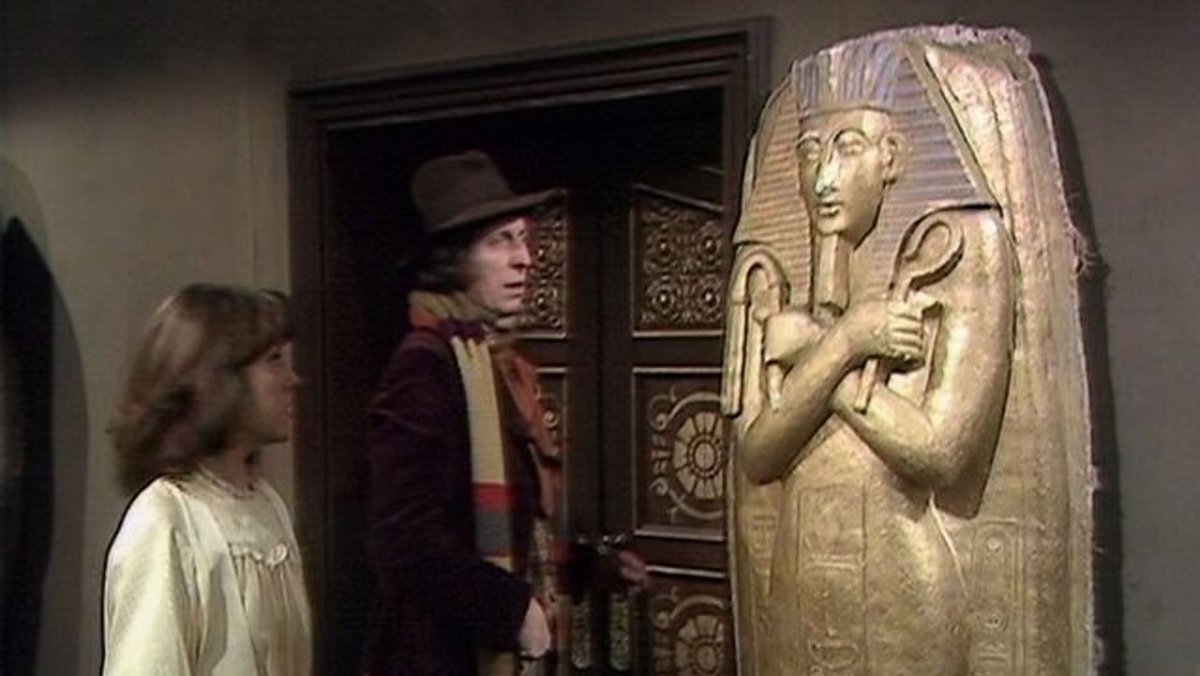 The Doctor and Sarah Jane look at a sarcophagus.