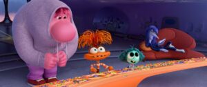 A hulking pink figure stands behind a frazzled orange one and a wide-eyed teal one. Behind them, a jaded-looking purple being sits on a couch.