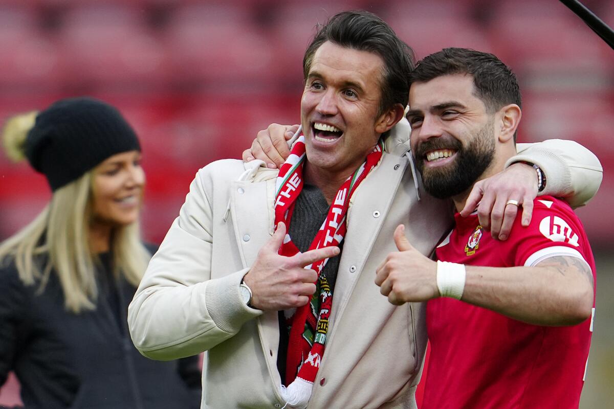 Wrexham co-owner Rob McElhenney, left, celebrates with Wrexham's Elliot Lee after a match against Stockport on Saturday.