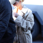 Kim Kardashian arrives at her son Saint’s basketball game sporting a baseball cap, tench coat, and her new blond hair