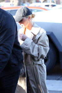 Kim Kardashian arrives at her son Saint’s basketball game sporting a baseball cap, tench coat, and her new blond hair
