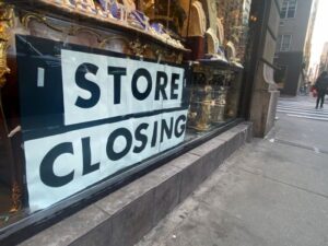 Store Closing sign in window of Antiques shop on Upper East Side, Manhattan
