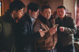 Ma Dong-seok and the lads look at a phone together in The Roundup: Punishment
