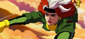 Rogue flies through colorful clouds, her hair streaming and a determined look on her face in X-Men ’97.