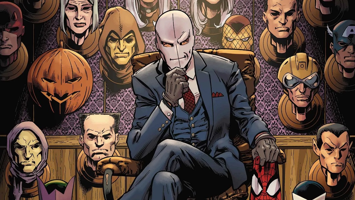Chameleon sits in a chair surrounded by dozens of masks of Spider-Man characters.