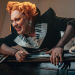 Jinkx Monsoon villain character Maestro leans over the top of a piano in doctor who episode