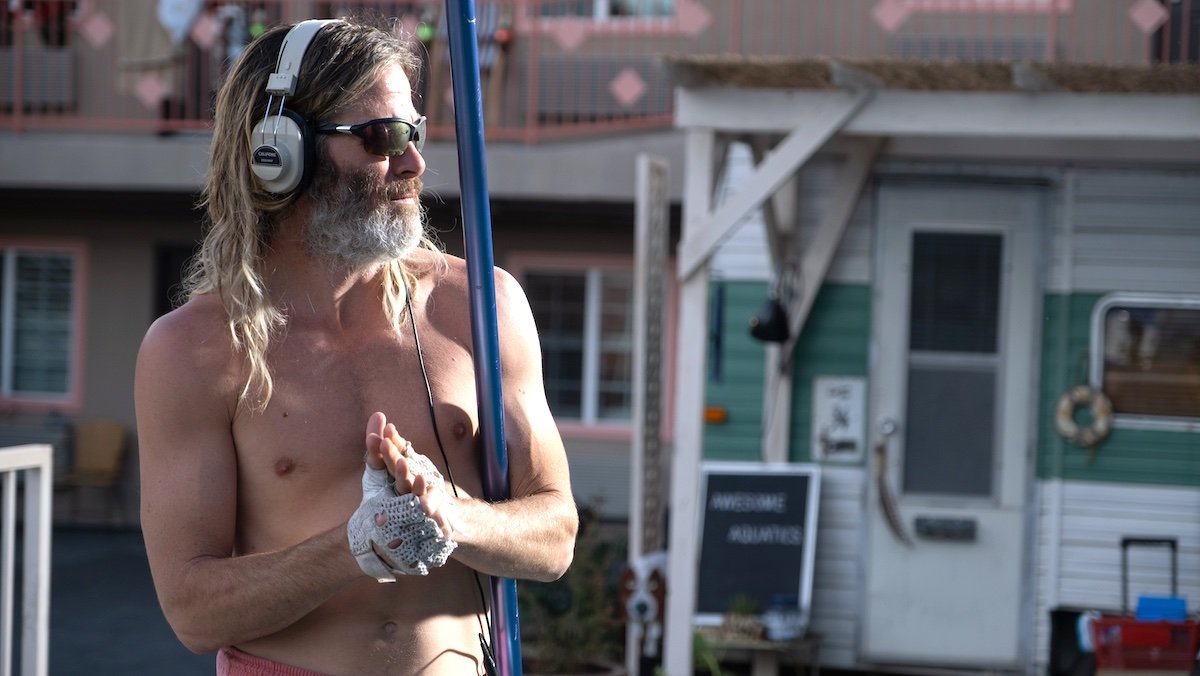 A shirtless, long-haired Chris Pine working in Poolman