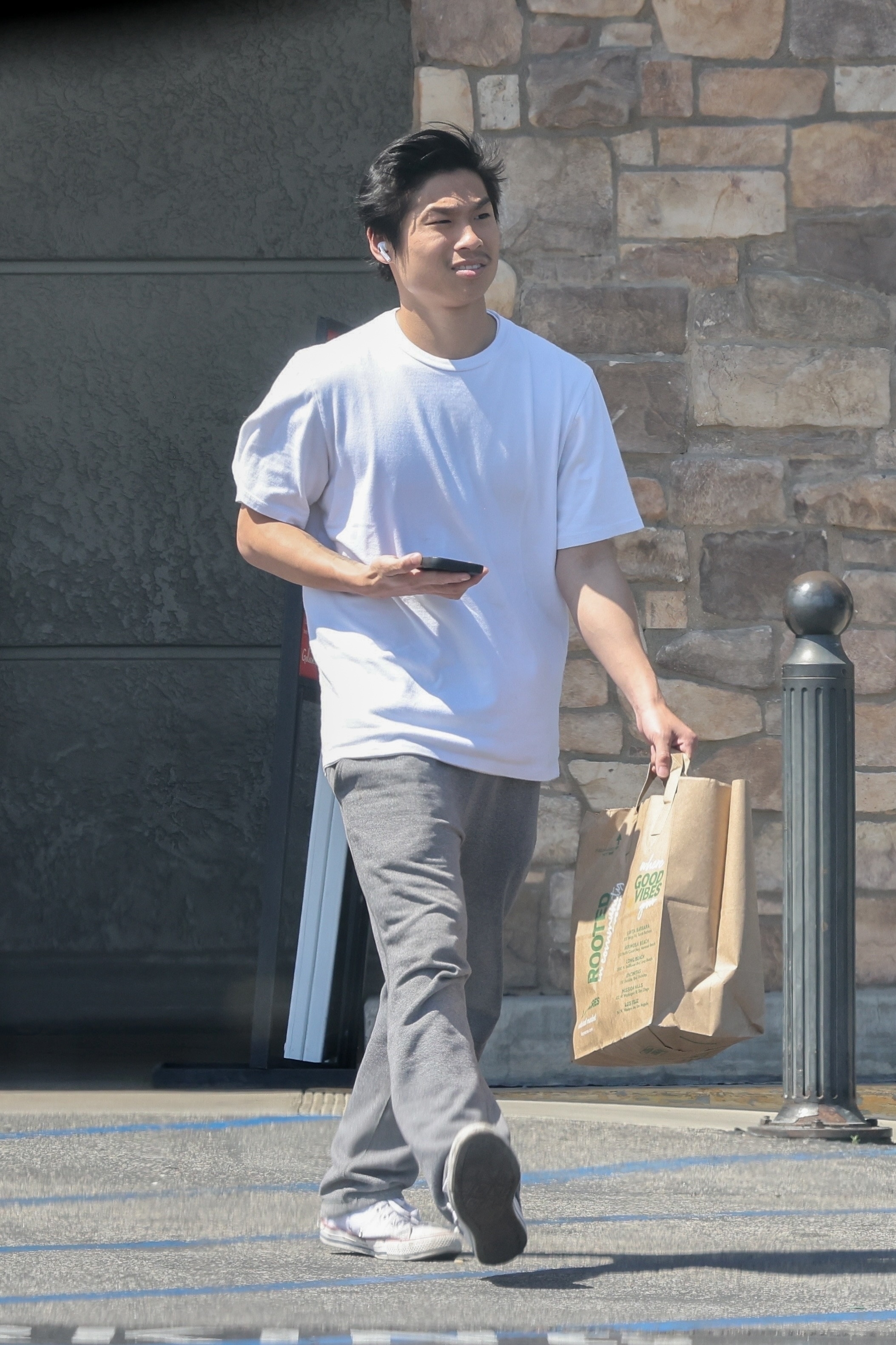 He flashed a smile in a baggy outfit while brisky picking up groceries