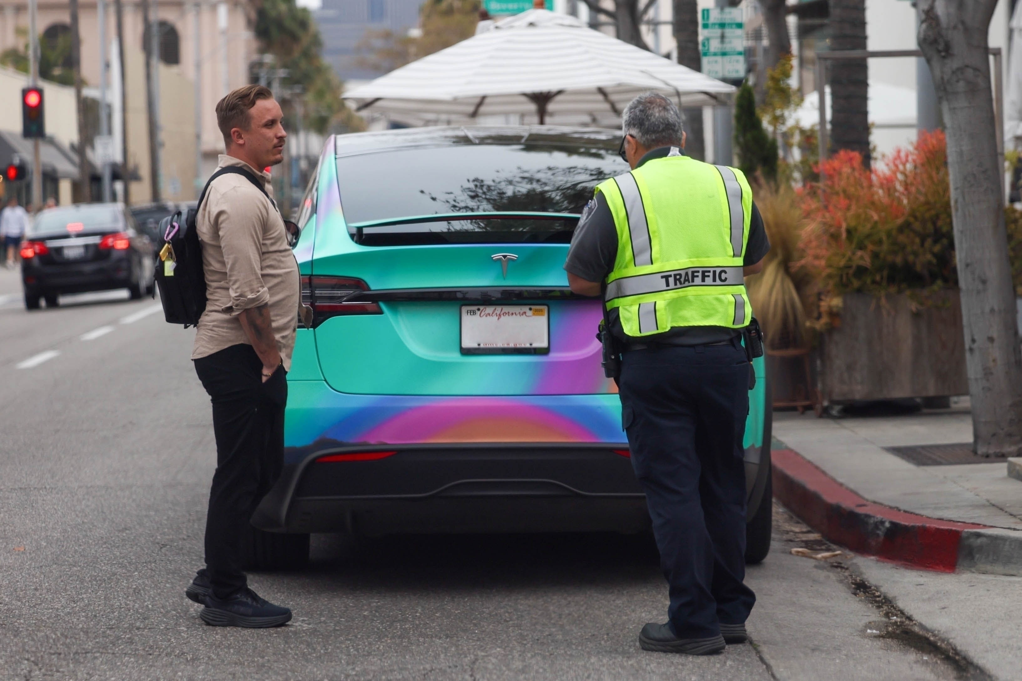 Jaden and Sab were spotted approaching his colorful Tesla Model X soon after parking enforcement had ticketed the red zone-parked vehicle
