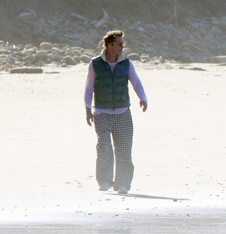 Brad trekked through the sand along the shoreline in a warm, puffer vest