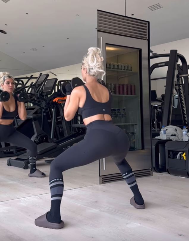 Kim squatted while lifting weights up to her shoulders in the video