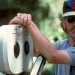 Steven Spielberg standing by a Panasonic 35mm camera on the set of Jurassic Park.