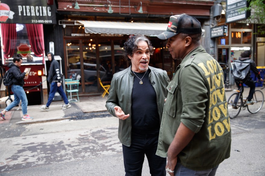 Oates speaking with Arnold near the location of the original Gaslight Cafe, where he played as young musician.