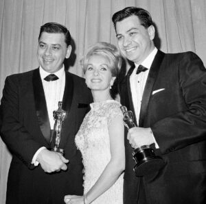 Actress Debbie Reynolds poses with Academy Awards winners for best music Richard M. Sherman, right, and Robert Sherman, left.
