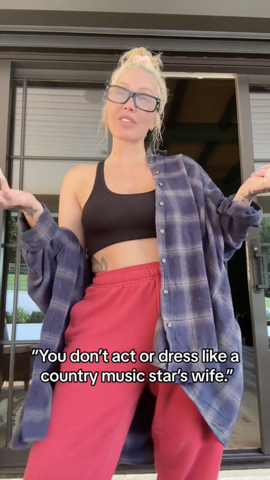 In the TikTok, Bunnie stood outside wearing a loose-fitting flannel over a black sports bra that she paired with red sweatpants