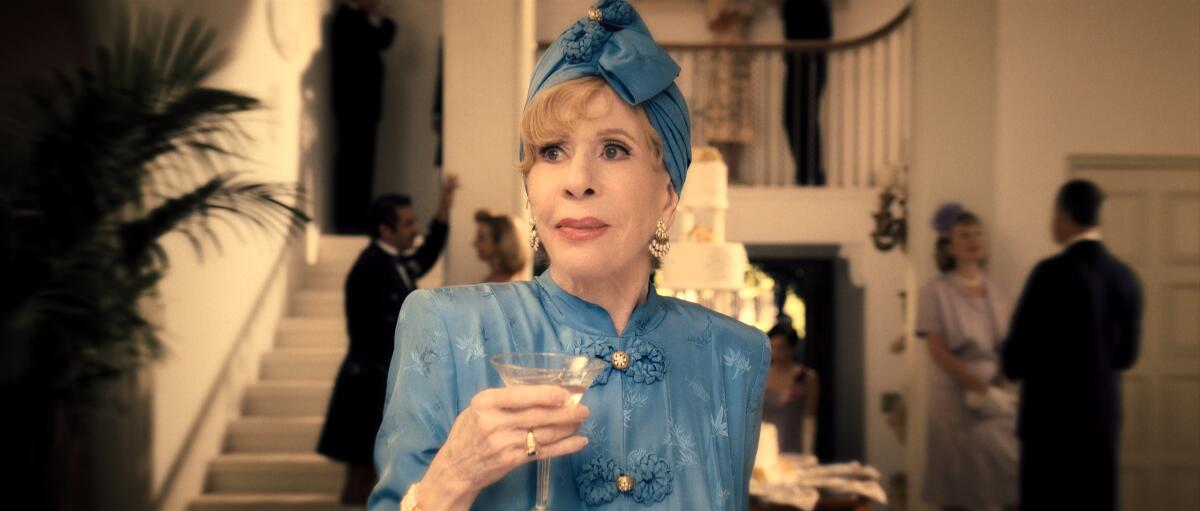 Carol Burnett, holding a martini, wears a blue dress with matching turban