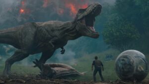 A T.Rex roars n front of an erupting volcano as a man looks on in Jurassic World: Fallen Kingdom