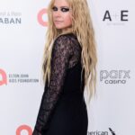 Avril Lavigne posing in a black dress at the Elton John AIDS Foundation Academy Awards Viewing Party in Los Angeles, March 10, 2024