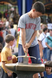 FRANCE - AUGUST 03: A young visitor tries to remove Excalibur at Euro Disney amusement park near Paris, France,Tuesday, August 3, 2004. Euro Disney SCA, Europe’s largest operator of theme parks, said its loss widened in fiscal 2004 as the company spent more on advertising and royalty payments to parent Walt Disney Co. (GETTY)