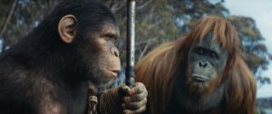 Noa (a chimp) and Raka (an orangutan) from Kingdom of the Planet of the Apes look at each other while Noa holds a weapon