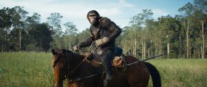 Noa, a chimpanzee, rides a horse in front of a forest in the film Kingdom of the Planet of the Apes