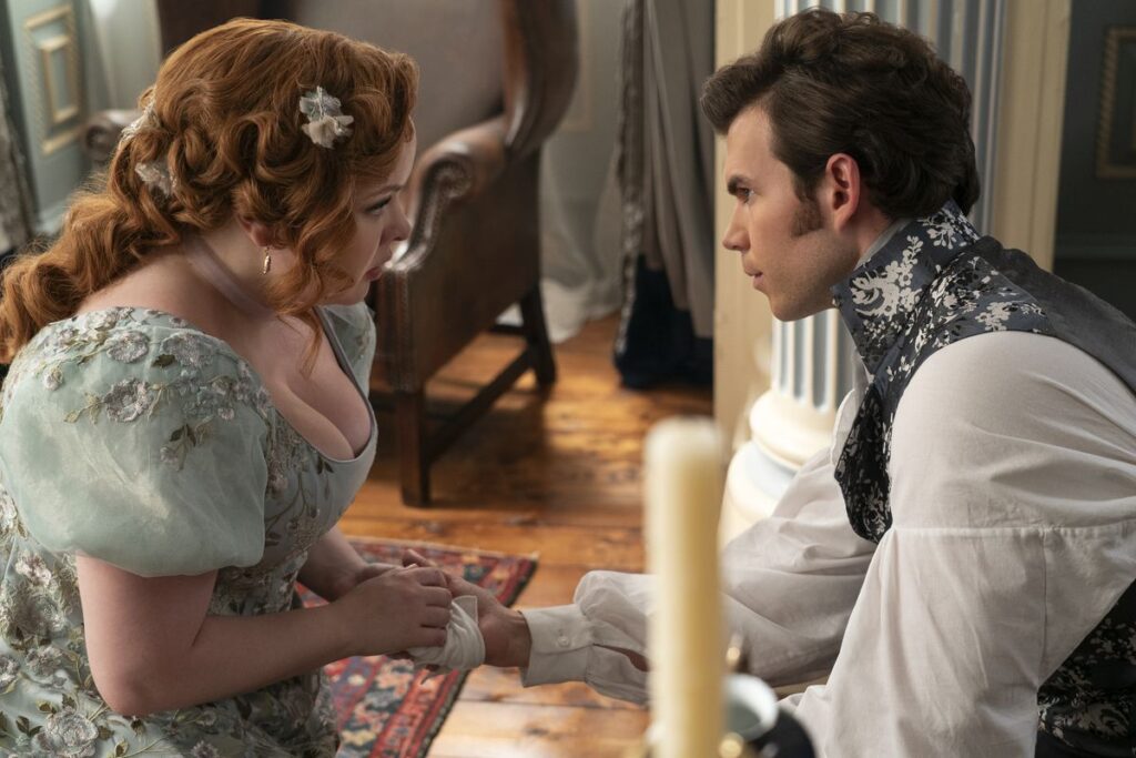 Colin (Luke Newton) and Penelope (Nicola Coughlan) share some steamy eye contact as she mends his wounded hand