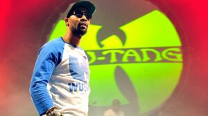 RZA in front of the Wu-Tang Clan logo