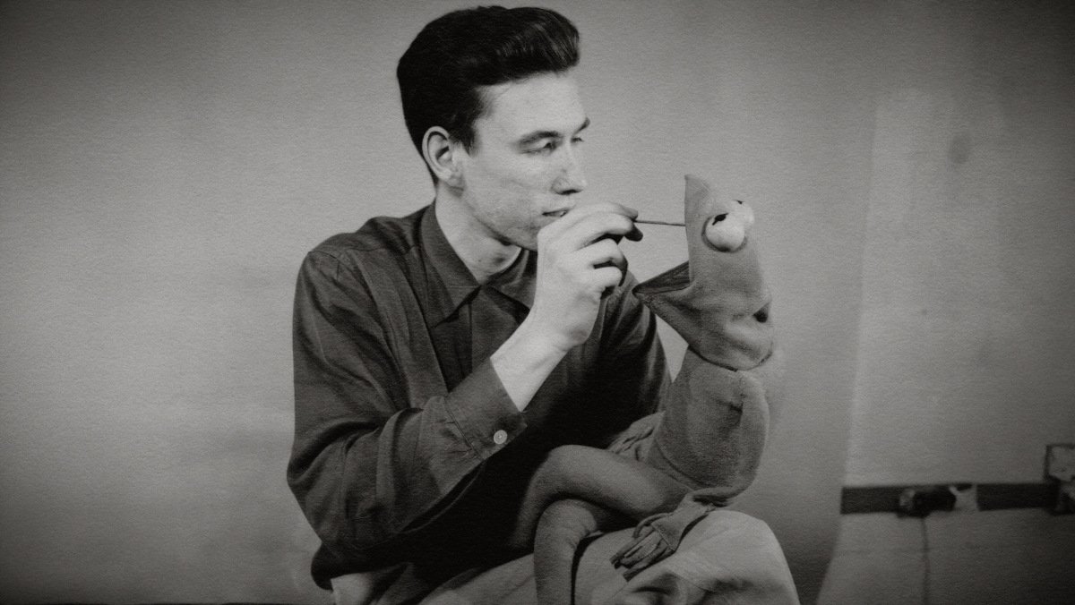 A black and white picture of a young Jim Henson working on the Kermit the Frog puppet from the Jim Henson documentary Jim Henson Idea Man