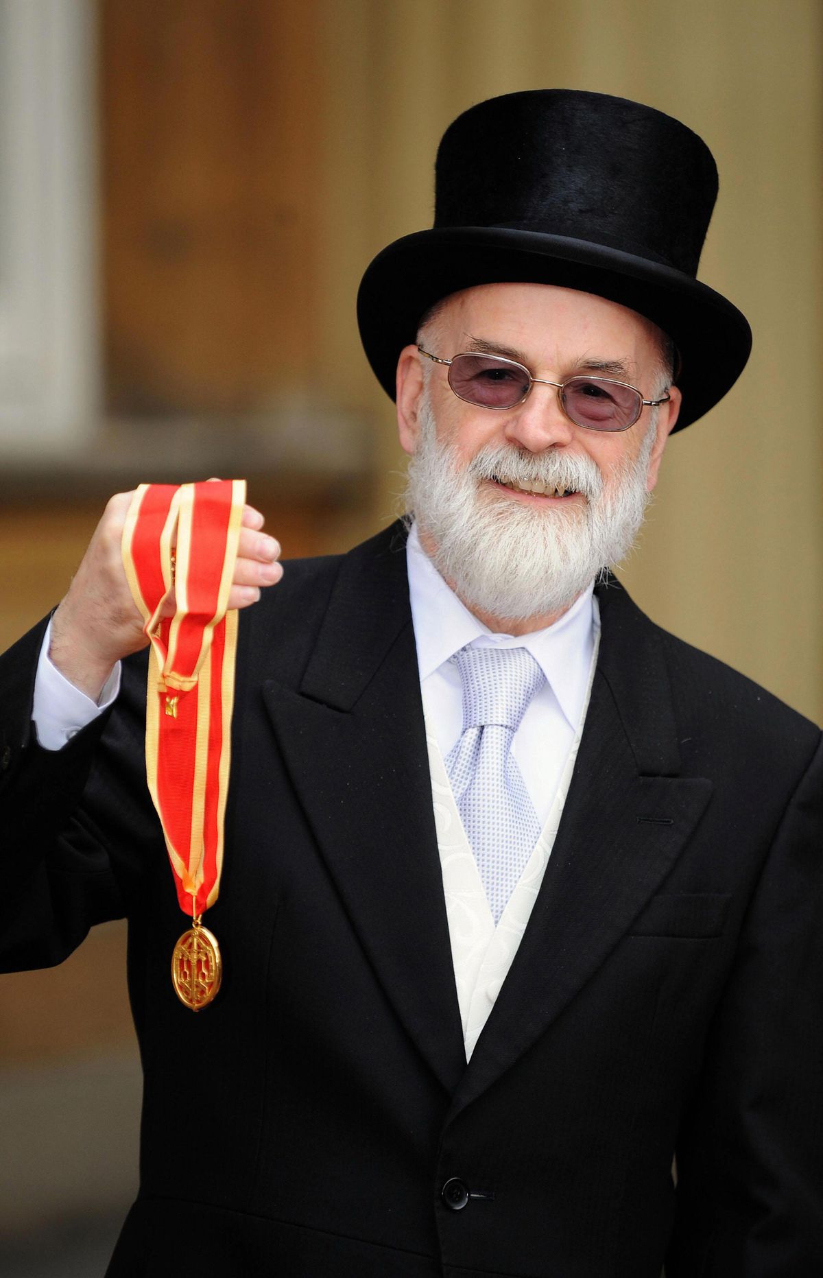 Sir Terry Pratchett shows his knighthood award outside Buckingham Palace.