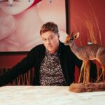 Alan Tudyk gives side-eye to a small deer statue in a portrait.