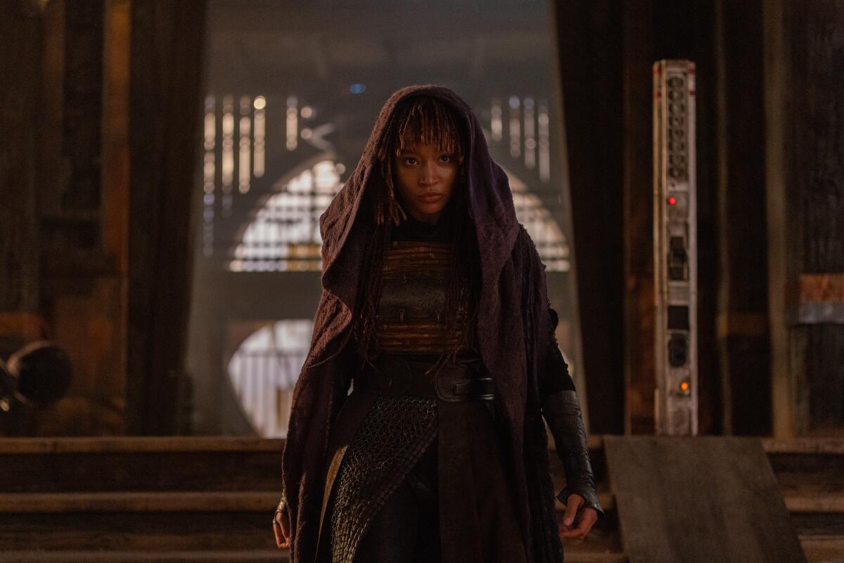 Amandla Stenberg wearing a hooded cloak