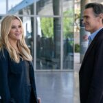 Reese Witherspoon and Billy Crudup chat in the lobby of a glass-walled building in "The Morning Show."