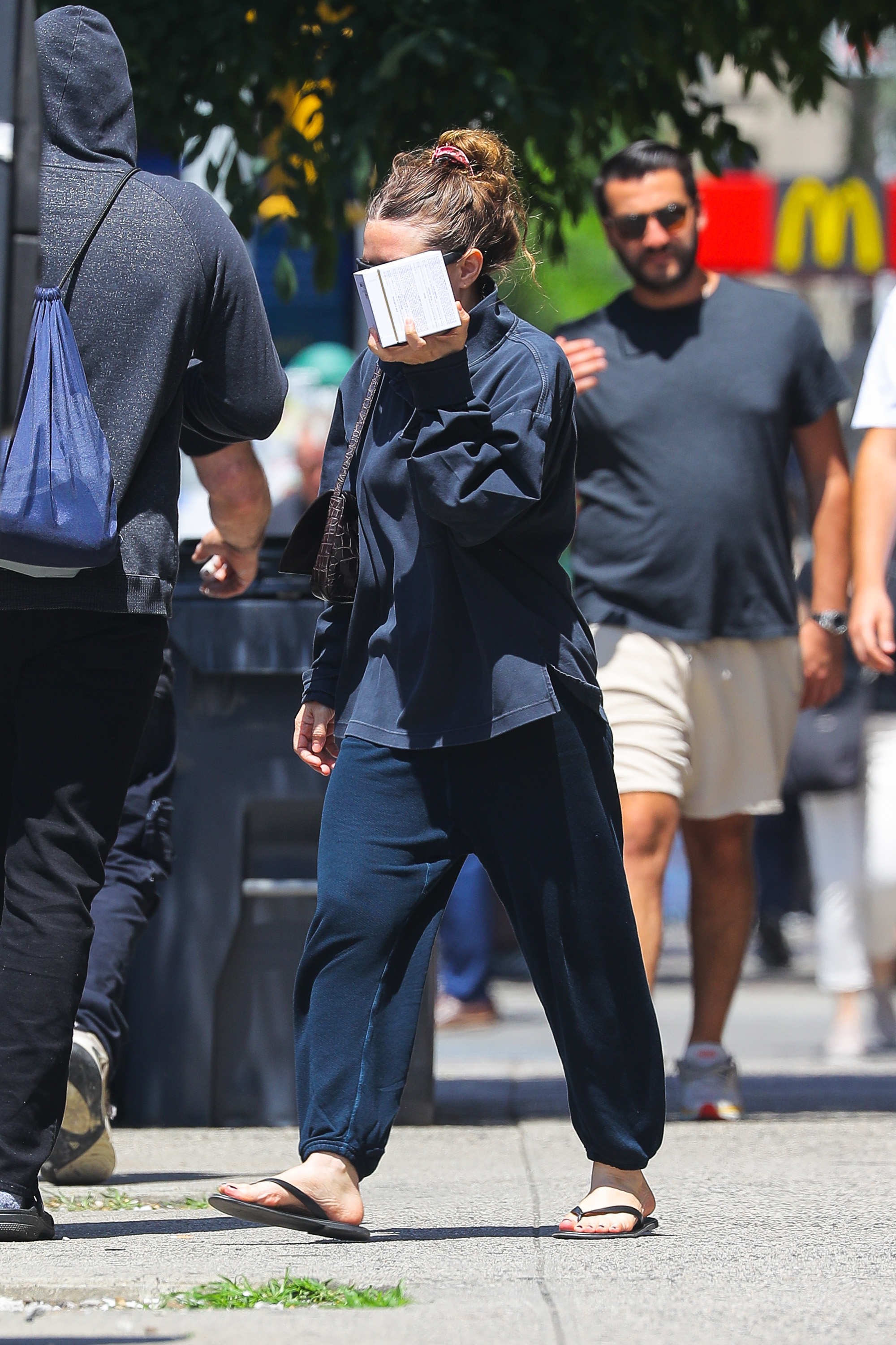 She paired the top with dark blue sweatpants and flip-flops